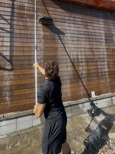 Washing a wooden façade with a telescopic pole