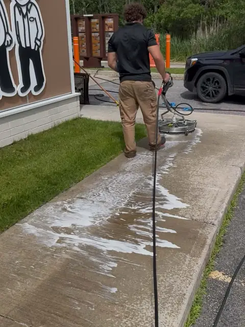 Cleaning a concrete sidewalk with a rotary surface-cleaner machine