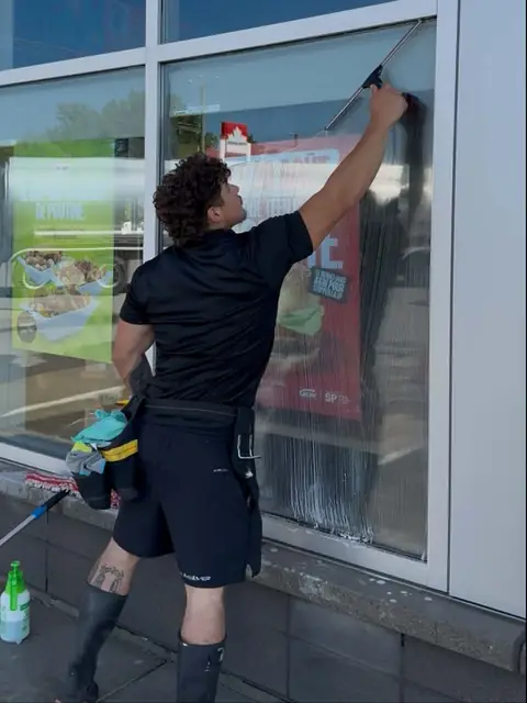 Squeegee cleaning of a large storefront window